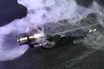 Modern electronic smoking device on black table, closeup