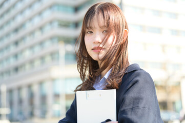バインダーを持って笑顔の日本人女性