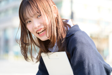 バインダーを持って笑顔の日本人女性