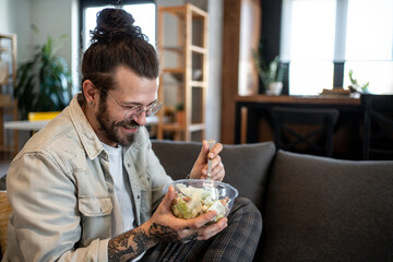 Happy freelancer enjoying healthy salad at home office