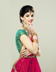Young attractive model dressed in posh, gildet, indian costume. Traditional Indian costume.