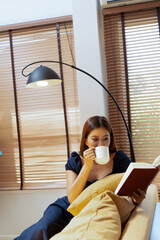 Woman enjoys book and music in modern abode.