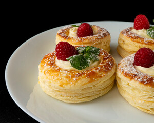 Gourmet dessert made with puff pastry, berries and cream on dark plate
