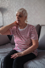 Old Age, Health Problem, Vision and People Concept - Close Up of Senior Woman Sitting on Sofa and Having Headache at Home. Elderly Woman With A Migraine