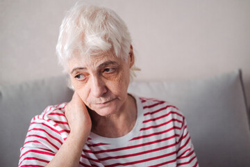 Old Age, Health Problem, Vision and People Concept - Close Up of Senior Woman Sitting on Sofa and Having Headache at Home. Elderly Woman With A Migraine