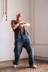 man in casual clothes dances in a room.