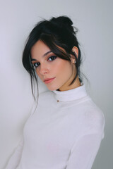 Young latin woman posing with white turtleneck and modern hairstyle