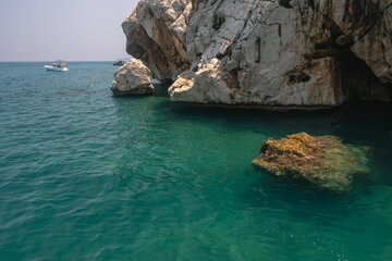 Yacht holidays in the Mediterranean Sea. In the sea, near the rocks, people relax on yachts. A sea...