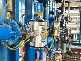 industrial equipment in a factory. Industrial reverse osmosis filtration system with stainless steel piping and control valves, used for water treatment in manufacturing.