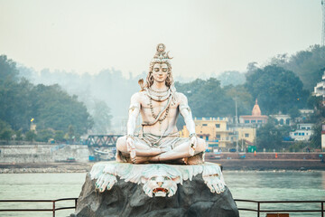 Lord Shiva statue on the banks of the Ganges River in Rishikesh, India – a symbol of peace, meditation, and spiritual power in Hinduism.