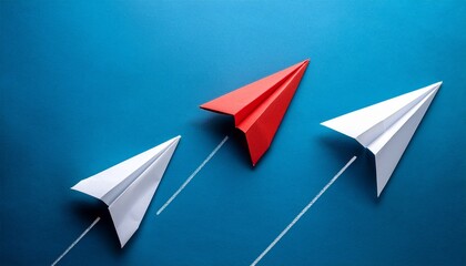 red paper plane leading two white paper planes on blue background symbolizing leadership innovation