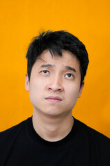 Fototapeta premium Young Man Expressing Displeasure Against Bright Orange Wall Background