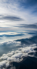 Naklejka premium Aerial view of misty mountains above clouds. Peaceful aerial scene of cloud-covered mountain peaks. 