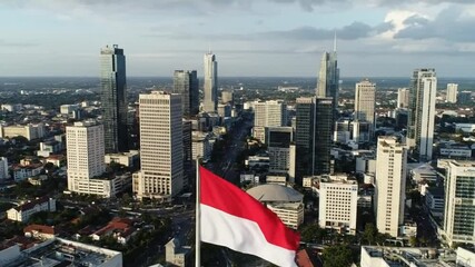 Drone Shot Pulling Away from Indonesian Flag Revealing Downtown Jakarta