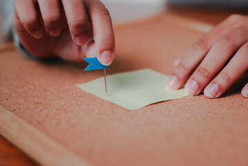 Business planning action organizing notes corkboard office environment focused viewpoint
