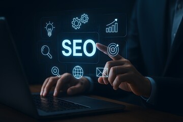 Naklejka premium Businessman interacting with virtual SEO interface and glowing digital marketing icons on laptop screen in dark office environment