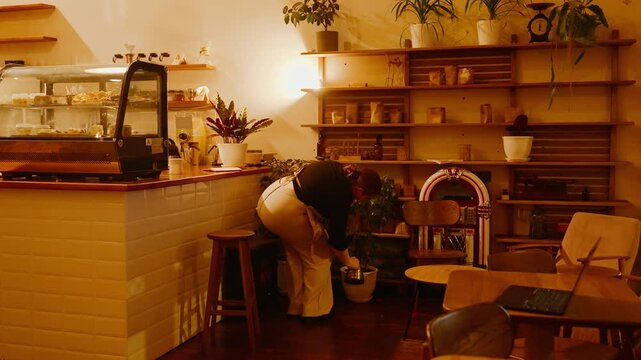 The female owner waters the plants in pots with a kettle