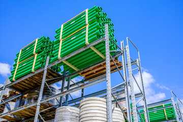 Bright and organized construction supplies stored on shelves under clear blue sky at a busy...