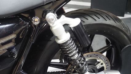 A motorcycle's rear suspension system, highlighting the shock absorber and coil spring