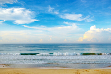 Bright morning landscape of blue sky with fluffy clouds and ocean coast.