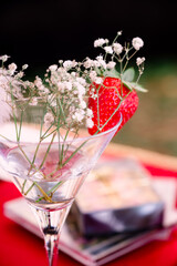 Floral Arrangement Featuring A Cocktail Glass & A Strawberry