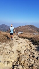 young man walking hiking in the desert landscape in Hong kong Lantau 