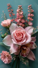 Fototapeta premium Elegant pink floral arrangement on teal background featuring roses and orchids