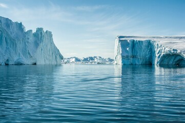 Large icebergs floating in the cold arctic or antarctic ocean.