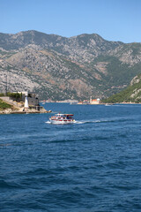 beautiful picture of a boat on the seashore with the Bay of Kotor and the island in the background. Mountains, sea