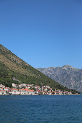Panorama of the old town in Montenegro against the backdrop of a mountain range and the sea. Vertical photo