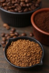 Different types of instant coffee and beans in bowls on wooden table, closeup