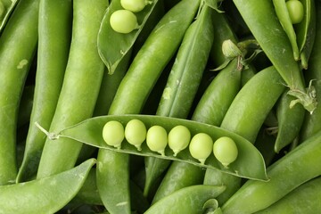 Fresh green peas and pods as background, top view