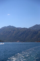 beautiful sea coast with waves, waves and blue sky against the backdrop of mountains