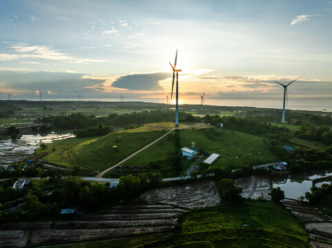 Aerial view of wind turbines standing tall against the horizon, casting long shadows over the landscape, San Lorenzo, Guimaras, Western Visayas, Philippines.