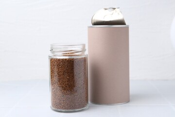 Instant coffee in jars on white tiled table, closeup
