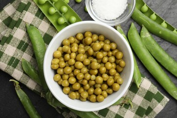 Pickled peas, salt and pods on black table, flat lay