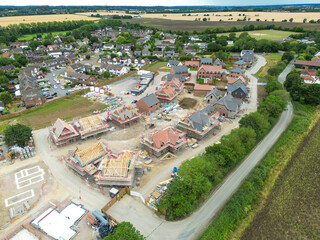 Drone view of a a partially completed British housing development site in rural east anglia. Both affordable and larger private, detached family homes can be seen.