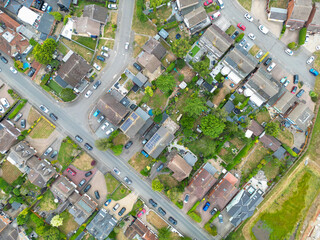 Drone view of a typical British suburban street showing both terraced and detached houses, some with large extensions and fitted solar panels to the roofs.