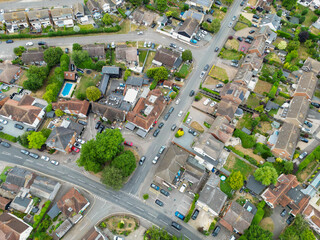 Drone view of a typical British suburban street showing both terraced and detached houses, some with large extensions and fitted solar panels to the roofs.