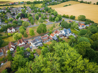 Aerial view of fine, detached and large private houses located within a rural community in England. Seen adjacent to the village green.