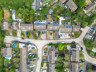 Drone view of a typical British suburban street showing both terraced and detached houses, some with large extensions and fitted solar panels to the roofs.
