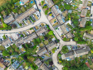 Drone view of a typical British suburban street showing both terraced and detached houses, some with large extensions and fitted solar panels to the roofs.