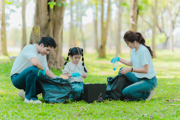 Asian family on summer vacation, parents teaching children to pick up plastic bottles and trash in...