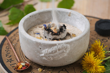 Incense bowl with frankincense and herbs on hot coal – atmospheric close-up