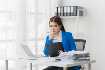 Focused Professional: A determined professional woman, deeply engrossed in reviewing documents and...