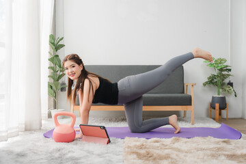 Woman's fitness at home: A woman focused and energetic performing at-home exercise, embracing a...