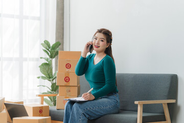 Young business woman working online e-commerce shopping at her shop. Young asia woman seller prepare parcel box of product for deliver to customer. Online selling. E-commerce.