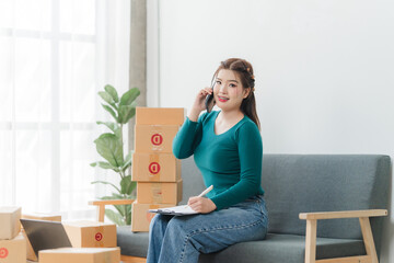 Young business woman working online e-commerce shopping at her shop. Young asia woman seller prepare parcel box of product for deliver to customer. Online selling. E-commerce.