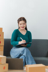 Young business woman working online e-commerce shopping at her shop. Young asia woman seller...