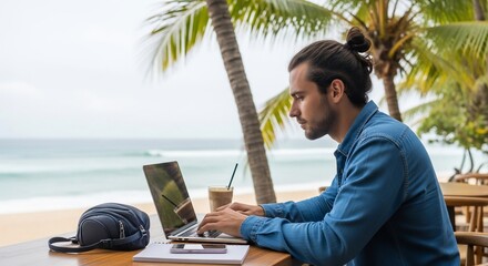 Man Working on Laptop by the Beach with Palm Trees and Iced Coffee